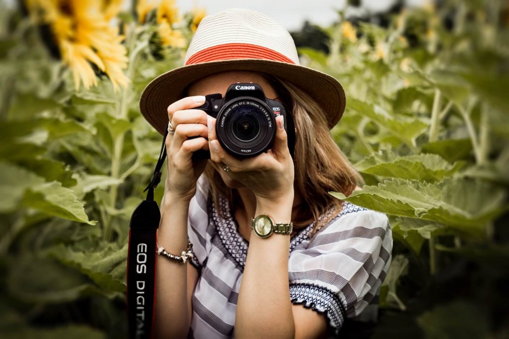 Una mujer capturando el momento con una cámara, concentrada y lista para tomar una fotografía